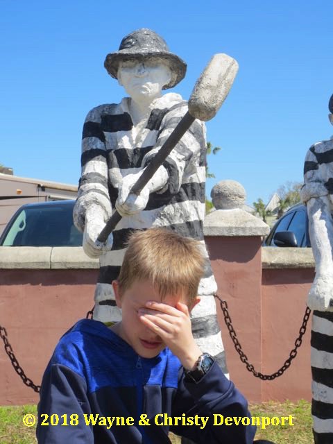 Colby underneath the guy holding  a hammer (chain gang statue)