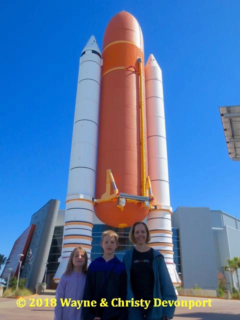 Denali, Colby, and Christy in front of space shuttle solid rocket boosters and fuel tank